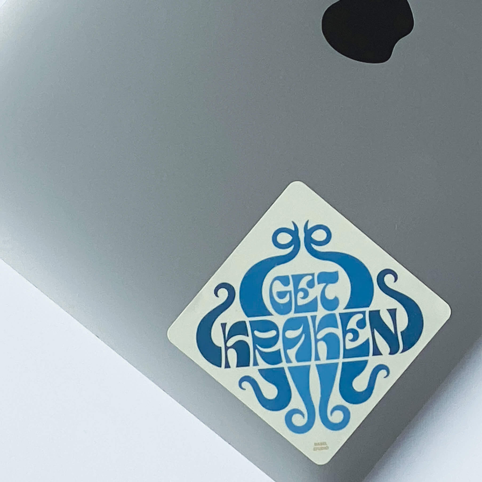 Sticker with 'get kraken' design in blue on laptop