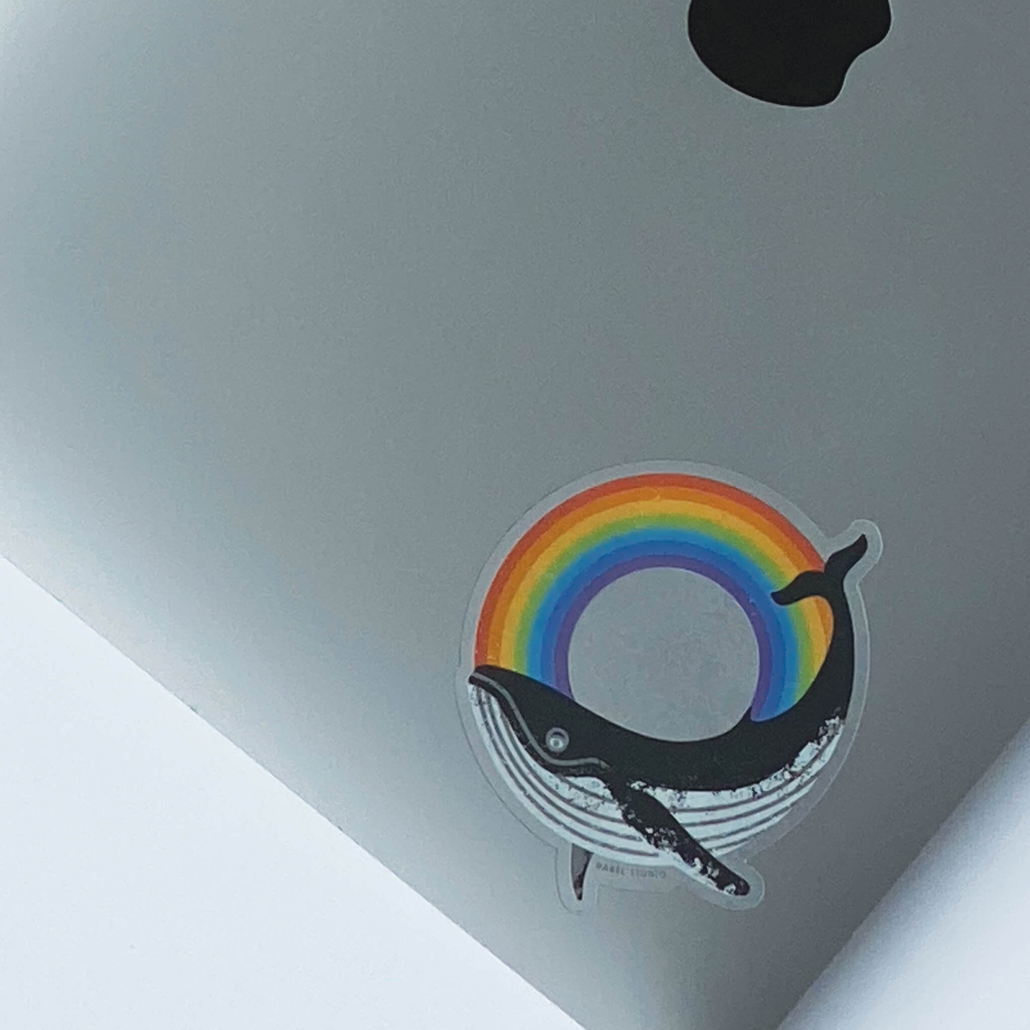 Sticker of illustration of whale and rainbow on laptop